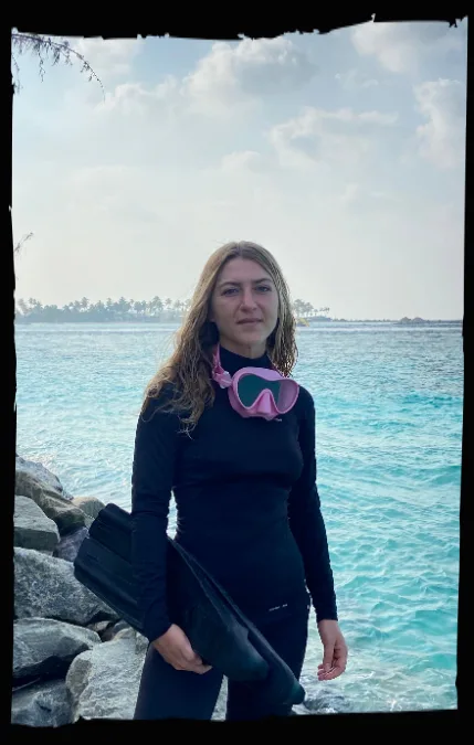 Femme en combinaison de plongée tenant un propulseur en bord de mer