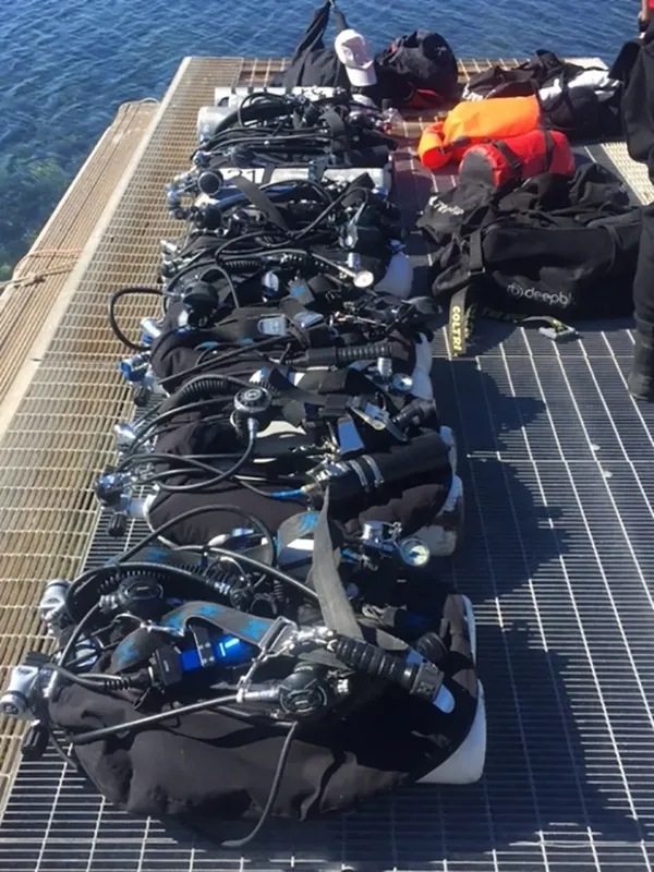 Equipement de plongée aligné sur un ponton en bois au soleil