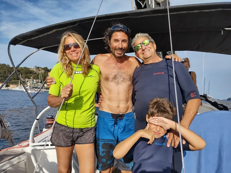Quatre personnes souriantes sur un bateau en mer, journée ensoleillée
