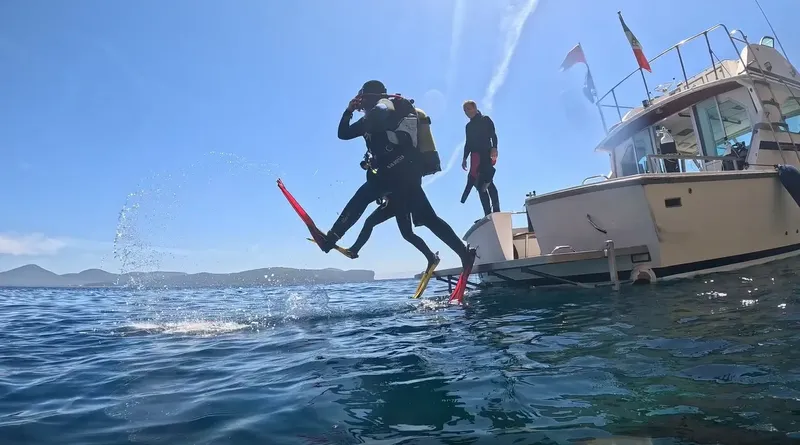 Plongeur s'apprête à entrer dans l'eau depuis un bateau de plongée