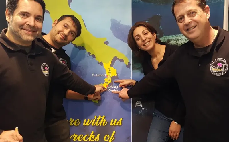 Trois personnes souriantes posent devant une carte de la Calabre