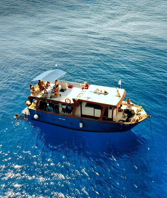 Bateau de plongée bleu avec des passagers, en pleine mer