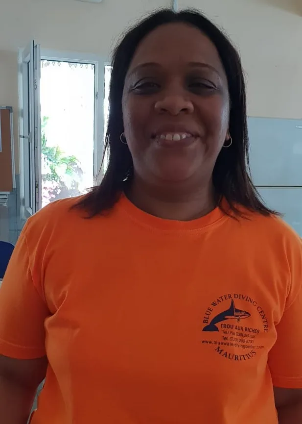 Portrait d'une femme souriante portant un t-shirt orange avec un logo