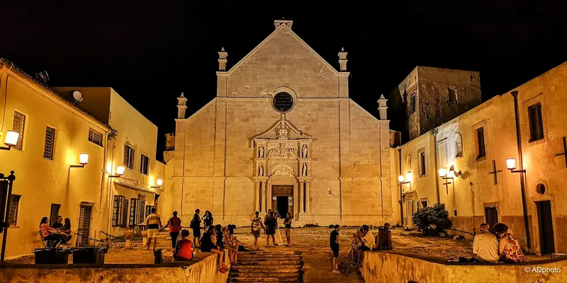 Groupe de personnes devant une église illuminée la nuit
