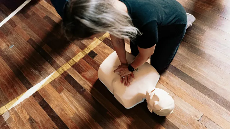 Une personne effectue un massage cardiaque sur un mannequin d'entraînement