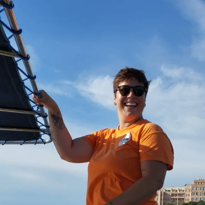 Femme souriante avec lunettes de soleil sur un ponton ensoleillé
