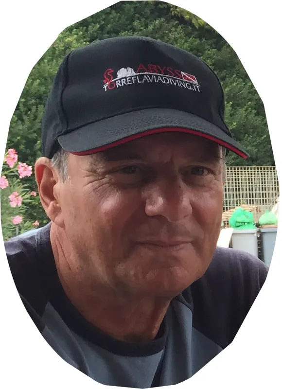 Portrait d'un homme souriant portant une casquette de plongée noire