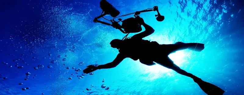 Plongeur en silhouette, équipé, explorant les profondeurs bleues de l'océan