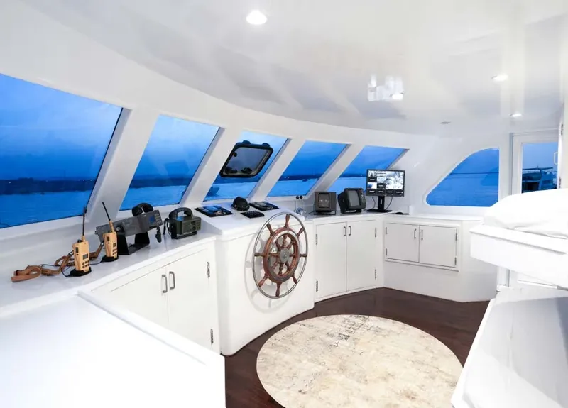 Intérieur clair d'un bateau avec barre à roue et écrans de navigation