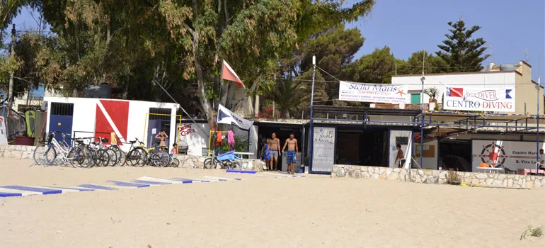 Centre de plongée sur une plage avec des personnes et du matériel