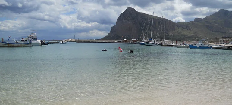 Plongée en surface dans un port abrité avec des bateaux et montagnes