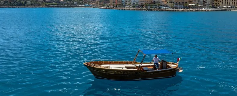Un homme se tient debout sur un bateau en bois sur l'eau