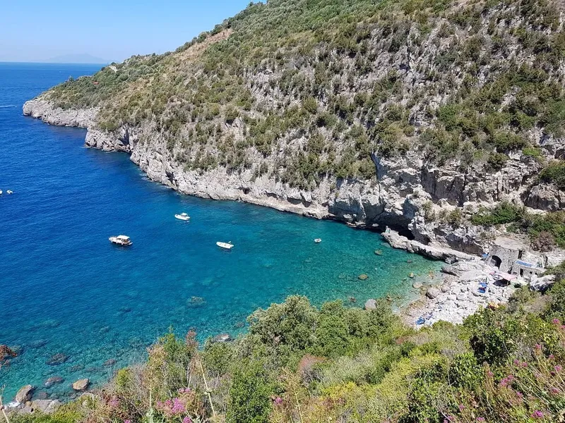 Vue aérienne d'une crique avec des bateaux et des personnes
