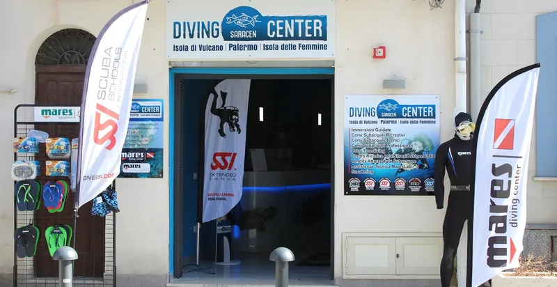 Entrée d'un centre de plongée avec enseigne, matériel et mannequins