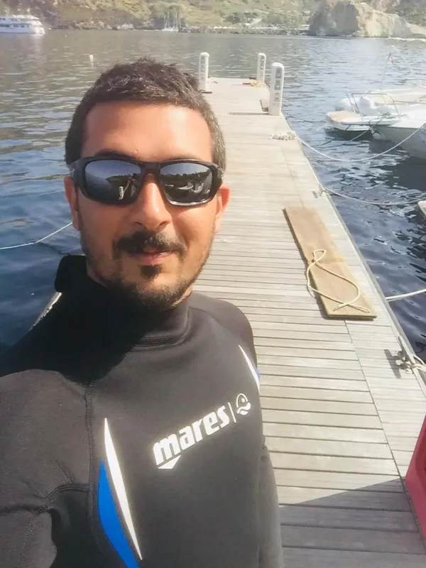 Homme en combinaison de plongée sur un ponton en bois