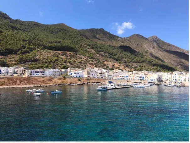Village côtier avec bateaux amarrés dans une baie ensoleillée