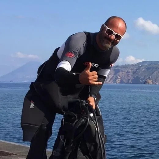 Plongeur équipé vérifiant son matériel près de la mer
