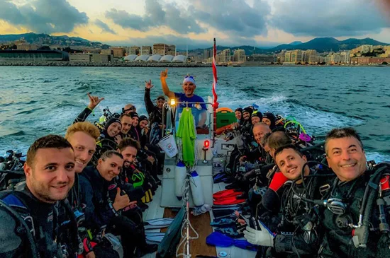 Groupe de plongeurs souriants sur un bateau en mer, ambiance joyeuse