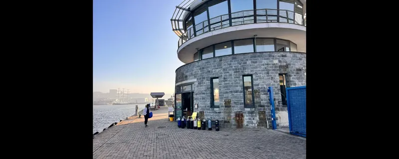 Bâtiment en pierre avec des bouteilles de plongée et une personne
