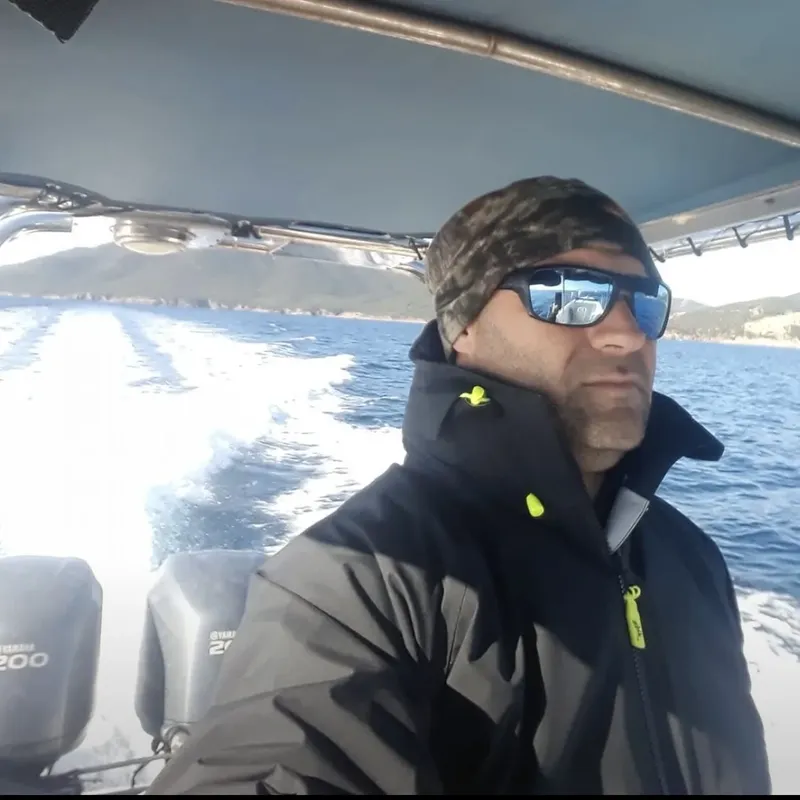 Homme portant des lunettes de soleil sur un bateau en mer