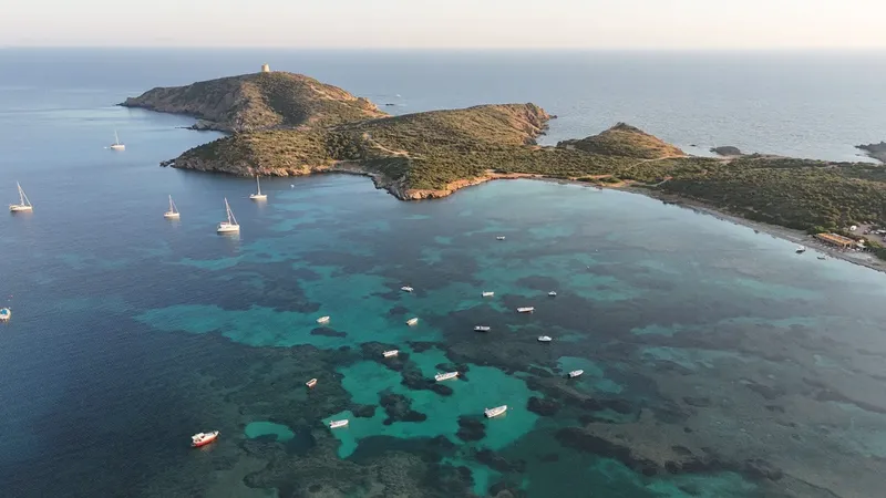 Vue aérienne d'une côte rocheuse avec des bateaux dans une eau turquoise