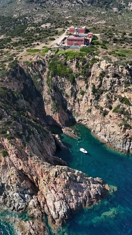 Vue aérienne d'une côte rocheuse avec un bâtiment et un bateau