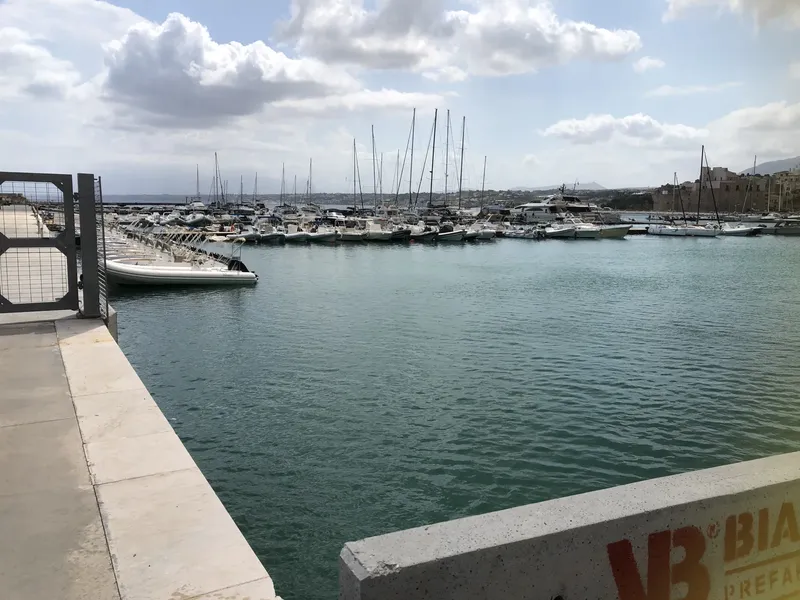 Port de plaisance avec de nombreux bateaux amarrés sous un ciel nuageux