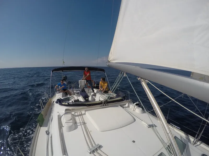 Quatre personnes à bord d'un voilier naviguant sur une mer bleue