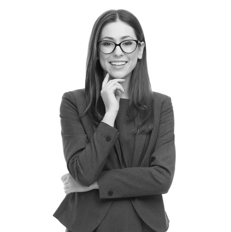 Portrait d'une jeune femme souriante en costume et lunettes