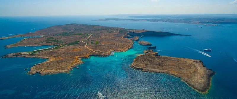 Vue aérienne d'une île rocheuse entourée d'eaux turquoise et bleues