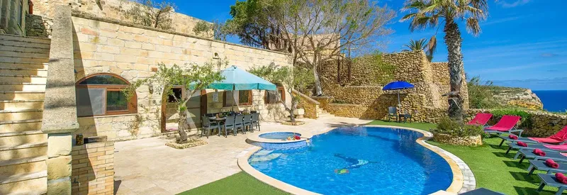 Piscine extérieure d'un centre avec terrasse, chaises longues et végétation luxuriante
