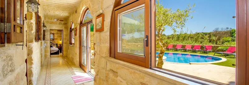 Intérieur d'une maison avec vue sur une piscine et un jardin