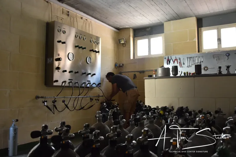 Un homme travaille sur un panneau de bornes de remplissage de bouteilles