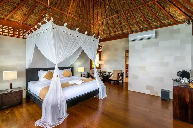 Chambre d'hôtel luxueuse avec lit à baldaquin et décoration tropicale