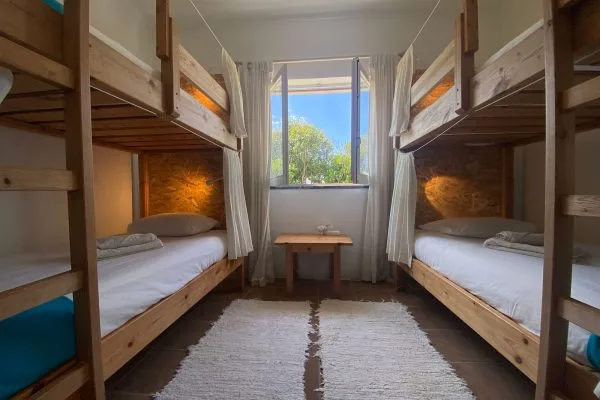 Dortoir avec lits superposés, fenêtre et table basse en bois