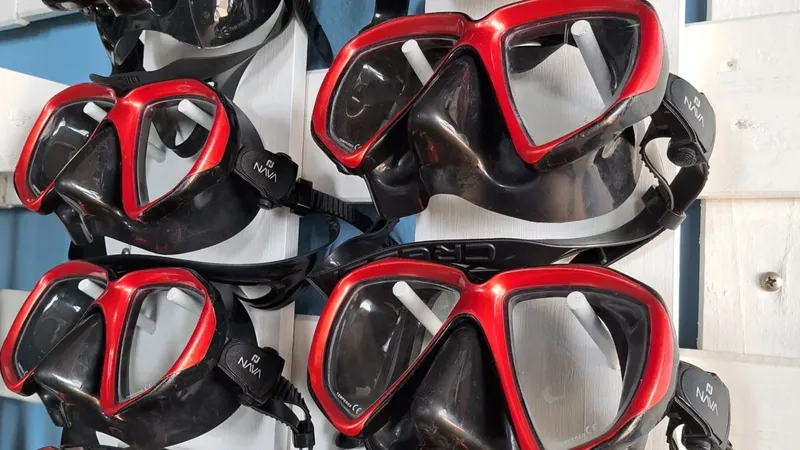 Rangée de masques de plongée noirs et rouges accrochés à un support