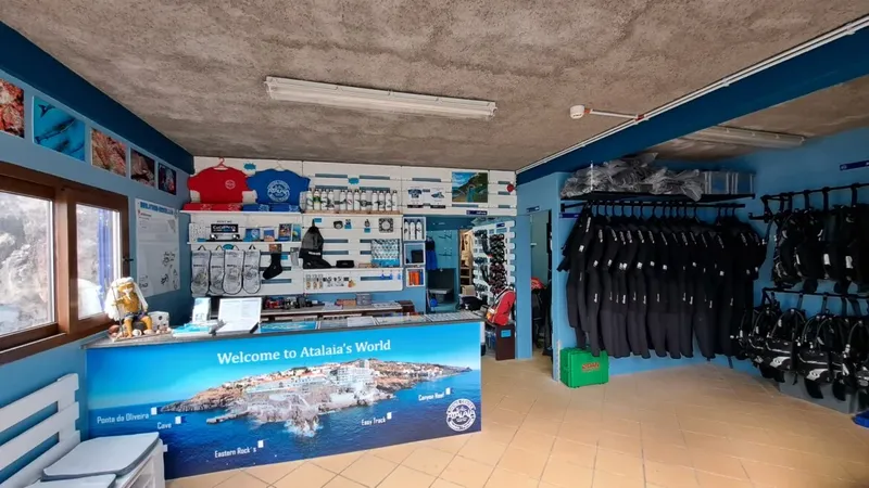 Intérieur d'un centre de plongée avec comptoir, combinaisons et équipements