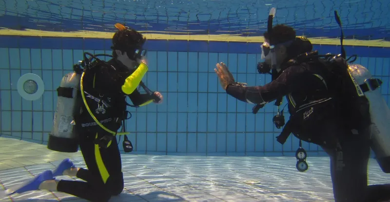 Deux plongeurs en formation s'entraînent dans une piscine, interaction