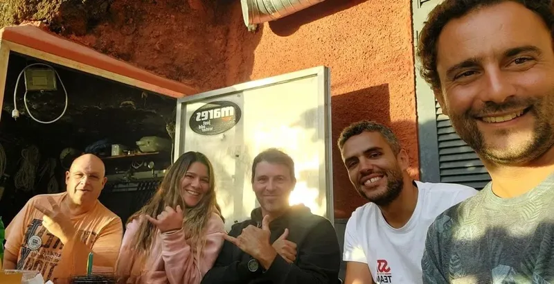 Quatre personnes souriantes posent devant la facade d'un centre