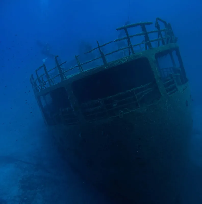 Épave de bateau rouillé reposant sur le fond marin bleu