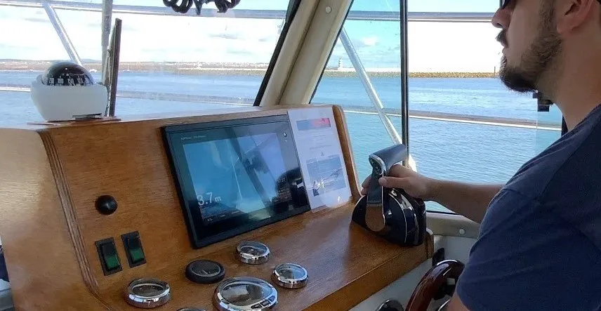 Homme conduisant un bateau avec un écran affichant des données