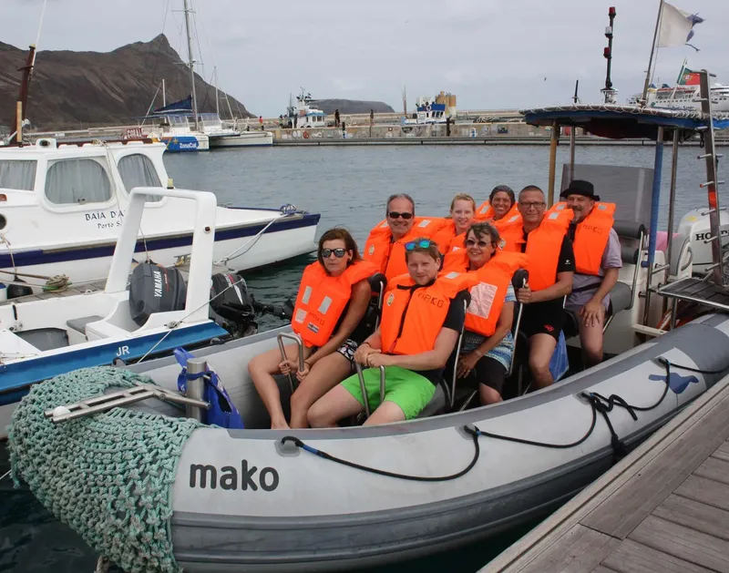 Groupe de personnes souriantes en gilets de sauvetage à bord d'un bateau