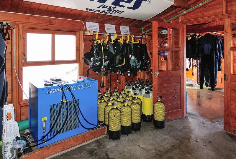 Équipement de plongée complet, compresseur, bouteilles et gilets de sauvetage rangés