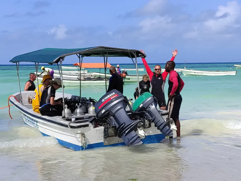 Plongée : des personnes montent à bord d'un bateau sur une plage