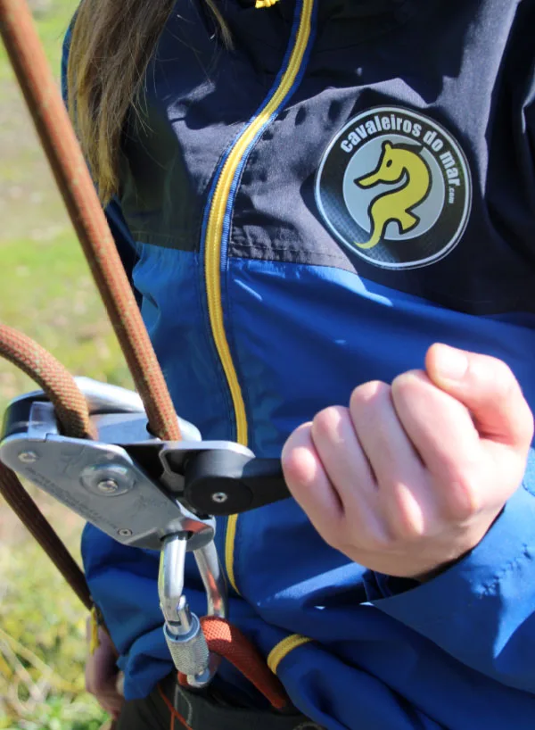 Personne tenant un mousqueton avec un patch sur sa veste
