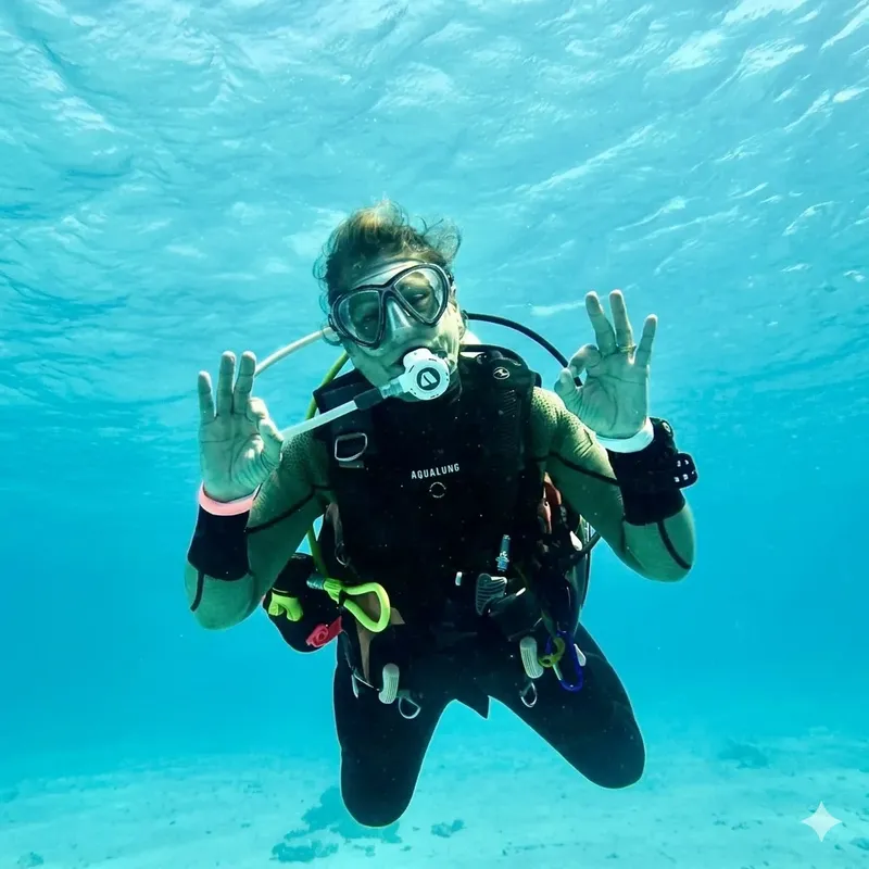 Plongeuse souriante avec combinaison et équipement complet sous l'eau