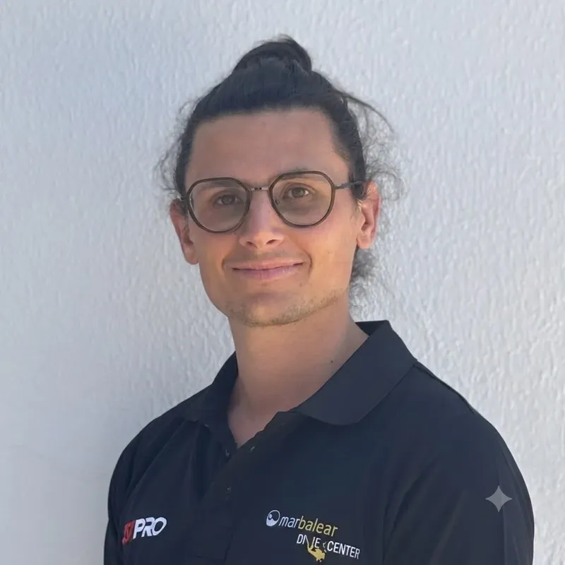 Portrait d'un homme souriant avec des lunettes et un polo noir