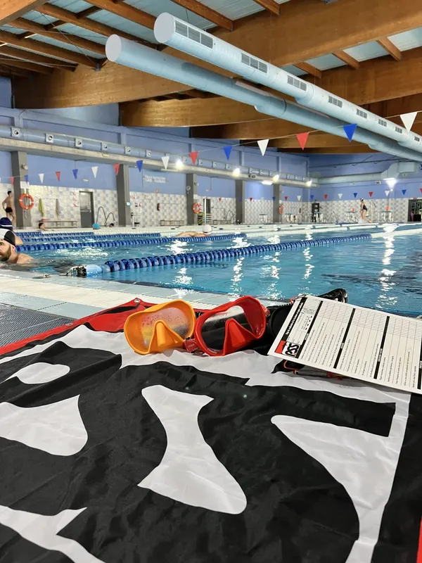 Piscine intérieure avec nageurs, matériel de plongée et documents