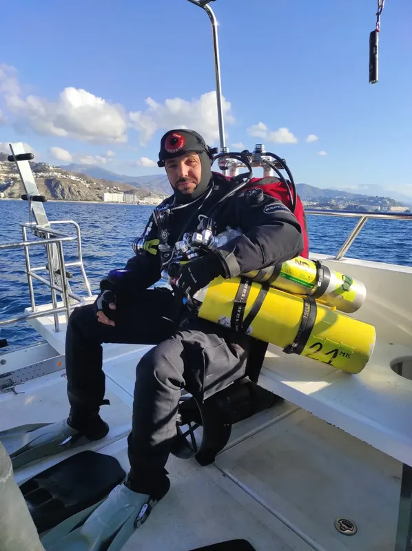 Plongeur équipé sur un bateau, prêt pour une immersion en mer