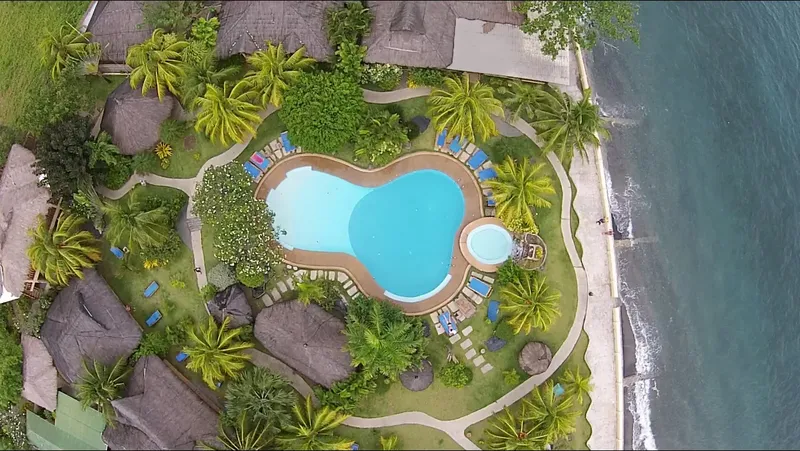 Vue aérienne d'un complexe hôtelier avec piscine et végétation tropicale